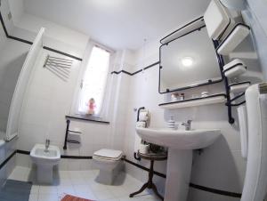 a white bathroom with a sink and a toilet at Blue Room Shared House Terrace above in Genoa +31 photos
