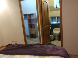 ein Schlafzimmer mit einer Tür, die sich zu einem Bad mit einem WC öffnet in der Unterkunft Bella habitación Hacienda Santo Domingo in San Lucas Sacatepéquez + 26 Fotos