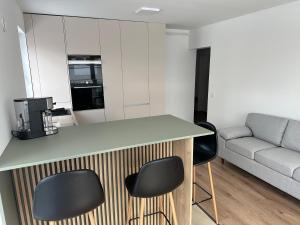 eine Küche mit einer Theke und zwei Stühlen und einer Couch in der Unterkunft Residence Unique in Râșnov