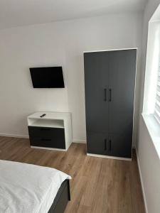 Schlafzimmer mit einem Bett, einem Schreibtisch und einem TV in der Unterkunft Residence Unique in Râșnov