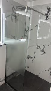 eine Glasdusche mit schwarzem und weißem Marmor in der Unterkunft Residence Unique in Râșnov + 20 Fotos