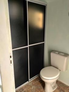 a bathroom with a toilet with black walls at Hotel Pousada e Parada Colonial in Capitão Leônidas Marques