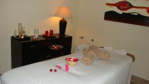 a hotel room with a white bed with a stuffed animal on it at Clube Pinhal da Foz in Esposende +26 photos