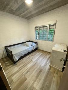 um quarto com uma cama e piso em madeira em Casa en Maldonado em Maldonado