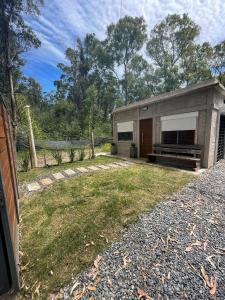 uma pequena casa num quintal com uma cerca em Casa en Maldonado em Maldonado