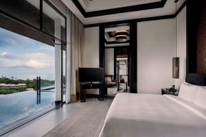 a bedroom with a bed and a view of the water at Banyan Tree Samui in Lamai