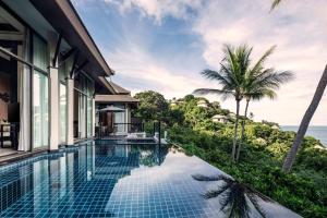 a pool at a resort with a view of the ocean at Banyan Tree Samui in Lamai