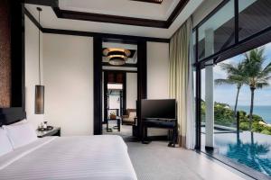 a bedroom with a bed and a view of the ocean at Banyan Tree Samui in Lamai