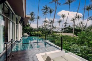 a house with a swimming pool and palm trees at Banyan Tree Samui in Lamai