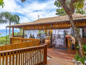 ein Haus mit einer Holzterrasse und einem Restaurant in der Unterkunft Eco Baepi Residence in Ilhabela
