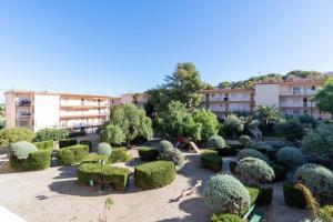 un jardín con arbustos y árboles frente a un edificio en Privilegiado-Tarragona-50mPlaya-WIFI-Pool-Relax8, en Tarragona