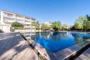 a large swimming pool with blue water in front of a building at Privilegiado-Tarragona-50mPlaya-WIFI-Pool-Relax8 in Tarragona