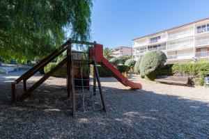 un parque infantil con un tobogán rojo en un parque en Privilegiado-Tarragona-50mPlaya-WIFI-Pool-Relax8, en Tarragona
