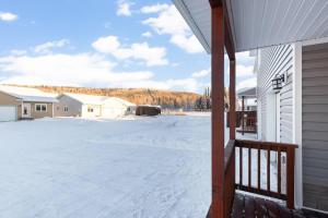 un patio cubierto de nieve junto a una casa en Birch Hill Retreat Great location2+gArAge+AurorA, en Fairbanks