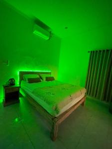 una camera verde con letto con struttura in legno di NAMA Guest House a Canggu