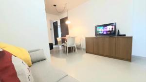 un soggiorno con TV e tavolo di Apto Santorini a Lauro de Freitas