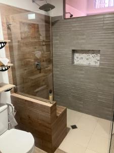 uma casa de banho com um chuveiro de madeira e um WC. em Casa Leon - Supia, Caldas em Supía
