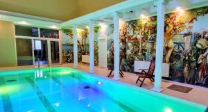 a swimming pool in a house with a mural at Zabava Guest House in Ivano-Frankivsk