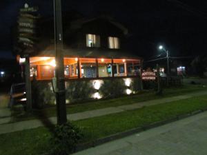 un edificio de noche con luces en el césped en Hostería Antupirén, en Hornopirén