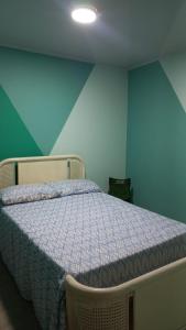 Cama en habitación con pared azul y verde en Casa Leon - Supia, Caldas, en Supía