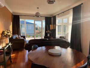 a living room with a table and a couch at Pinot Villas in Martinborough 