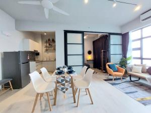 a living room with a table and white chairs at J'Stay Seaview Suite Jesselton Quay Kota Kinabalu in Kota Kinabalu
