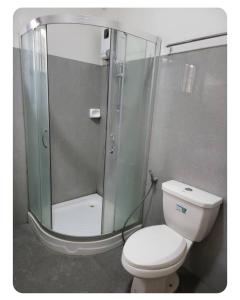 a bathroom with a toilet and a glass shower at Kame House in Bacoor