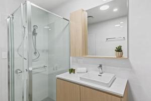 une salle de bain blanche avec un lavabo et une douche dans l'établissement Marina Escape - Contemporary Coastal Living, à Shellharbour 29 autres photos