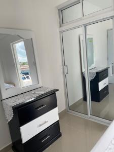 a bathroom with a black and white vanity and a mirror at Plataview Apartahotel apt 3C in Monte Plata