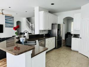 a kitchen with white cabinets and granite counter tops at Feel Home at Frisco in Frisco