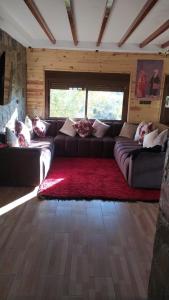 a living room with a couch and a red rug at Chez karim in Ifrane