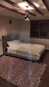 1 dormitorio con 1 cama con alfombra y techo en Chez karim, en Ifrane