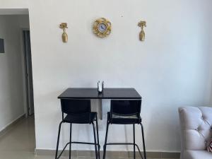 una mesa negra y 2 sillas en una habitación en Plataview Apartahotel apt 3C en Monte Plata