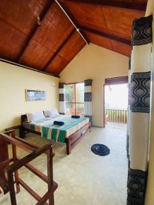 una camera con un letto e una grande finestra di Rainforest Nature House a Deniyaya