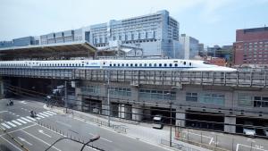 een trein bovenop een gebouw in een stad bij MIMARU KYOTO STATION in Kyoto