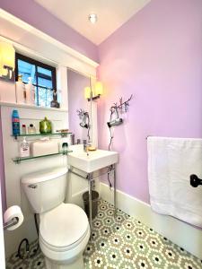 a bathroom with a white toilet and a sink at AristocratHomeStay in Vancouver