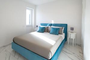 a bedroom with a large bed with blue accents at Tema Suites in Naples