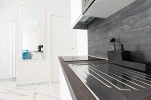 a kitchen with a stainless steel counter and a wall at Tema Suites in Naples