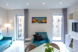 a living room with a blue couch and a table at Leucosia Suites - Dimore Partenopee in Naples