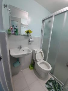 a white bathroom with a toilet and a sink at Mistow Saekyung Condo in Lapu Lapu City +5 photos