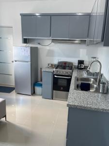 a kitchen with a stove and a sink and a refrigerator at Plataview Apartahotel apt 3C in Monte Plata