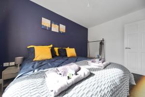 ein Schlafzimmer mit einem großen Bett mit gelben Kissen in der Unterkunft Exclusive house for contractors and families in Buttershaw