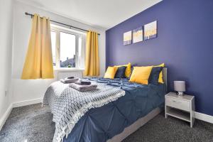 ein blaues Schlafzimmer mit einem Bett und einem Fenster in der Unterkunft Exclusive house for contractors and families in Buttershaw