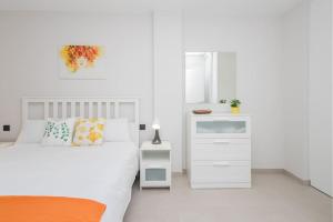 a white bedroom with a bed and a white cabinet at Coqueto apartamento cerca playa in Las Palmas de Gran Canaria