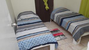 drie bedden in een kamer met een deur bij Sucasa apartement in Willemstad