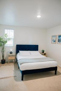 um quarto com uma cama grande e uma cabeceira azul em Monthly Rate Special - Heart of SLC em Salt Lake City