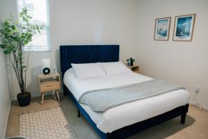 um quarto com uma cama com uma cabeceira azul em Monthly Rate Special - Heart of SLC em Salt Lake City