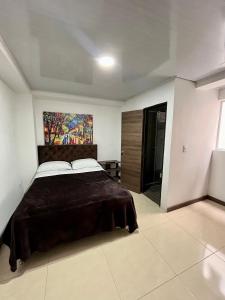 a bedroom with a bed and a painting on the wall at Amarena Hotel Boutique in Manizales