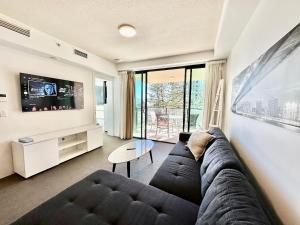 a living room with a couch and a tv at BB on the Park 504 in Gold Coast