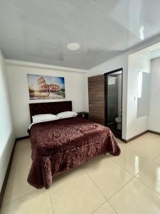 Amarena Hotel Boutique في مانيزاليس: غرفة نوم مع سرير وبطانية بنية اللون